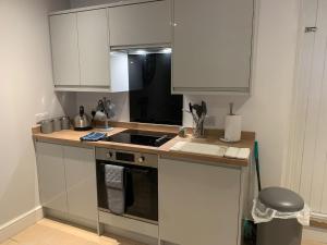 a kitchen with white cabinets and a stove top oven at One Bedroom Apartment in Bethesda in Bangor