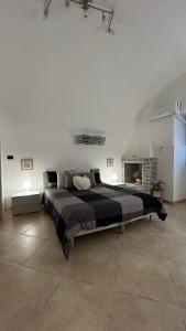 a large bed in a white room with a fireplace at Elly’s House in Bari