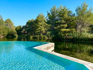 a swimming pool in the middle of a lake at Les Restanques Maison 12 Lac in Grimaud