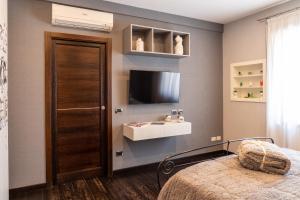 una camera da letto con un letto e una TV a parete di Nettuno's Suite a Napoli
