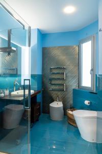 un bagno blu con vasca, servizi igienici e lavandino di Nettuno's Suite a Napoli