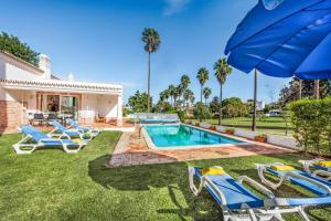 une cour avec une piscine entourée de chaises et d'un parasol dans l'établissement Casa Lorena, à Guia