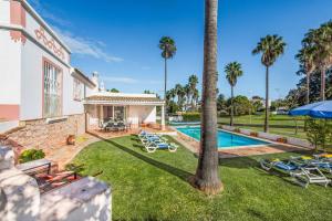 - une vue sur l'extérieur d'une maison avec une piscine et des palmiers dans l'établissement Casa Lorena, à Guia