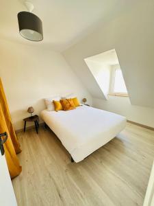 um quarto com uma grande cama branca com almofadas amarelas em Maison moderne cosy - Gestel em Gestel