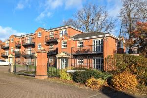 a large brick building with a fence in front of it at Superb Modern Apartment, FREE Secure Parking! in Allesley