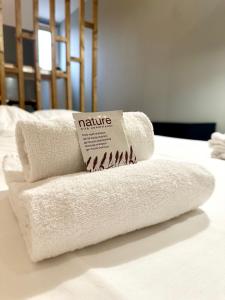 a stack of towels sitting on top of a bed at LE PANCAUT- Chaleureux - Hyper Centre in Mont-de-Marsan