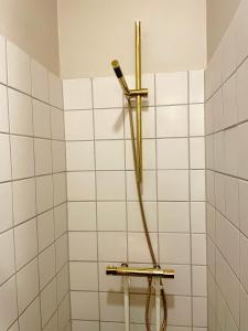 a white tiled bathroom with a shower with a hose at Michael's in Copenhagen