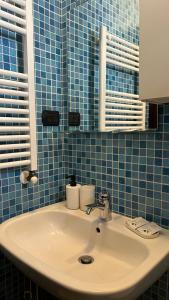 a bathroom with a white sink and blue tiles at Elly’s House in Bari