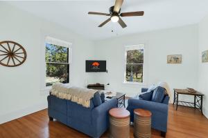 a living room with two blue couches and a ceiling fan at Twin Elm Cottage in Canyon Lake