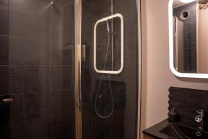 W łazience znajduje się prysznic ze szklanymi drzwiami. w obiekcie Chambre d hôte w mieście Saint-Herblain