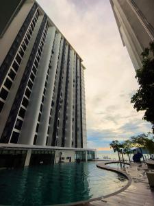 a large building with water in front of it at Lasa Lasa Sojourn 4 pax at The Shore seaview suites in Kota Kinabalu