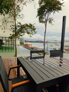 een picknicktafel met 2 stoelen en uitzicht op het water bij Just Chillin Seaview in Kota Kinabalu