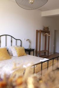 a bedroom with a large bed with yellow pillows at Maison - Les Traversières in Eymet