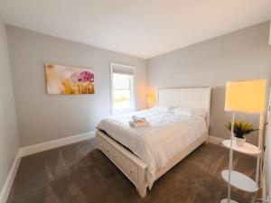 1 dormitorio con cama blanca y ventana en Charming Hyannis 3 Bed 2 Bath en Barnstable