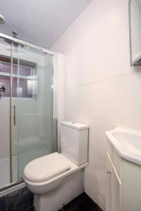 a white bathroom with a toilet and a sink at Charming North London Apartment in London