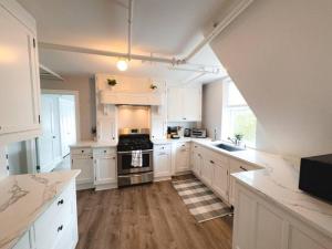 een keuken met witte kasten en een fornuis met oven bij Water Access 5-Bed 2-Bath Retreat in Barnstable