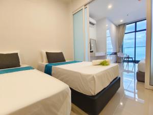twee bedden in een kamer met uitzicht op de oceaan bij Just Chillin Seaview in Kota Kinabalu