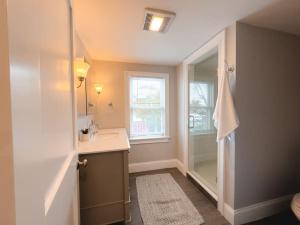 a bathroom with a shower and a sink and a mirror at Water Access 5-Bed 2-Bath Retreat in Barnstable +27 photos