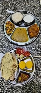 Musa's Homestay في جودبور: طبقين مع أنواع مختلفة من الطعام على طاولة