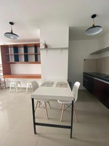 a dining room with a white table and chairs at Mono ambiente Cond Barak 1 in Santa Cruz de la Sierra