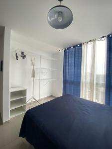 a bedroom with a blue bed and a window at Mono ambiente Cond Barak 1 in Santa Cruz de la Sierra