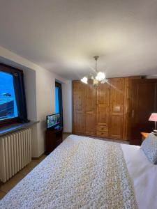 a bedroom with a large bed and a television at Il Nido di Letizia in Châtillon