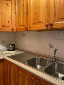 a kitchen with a stainless steel sink and wooden cabinets at Il Nido di Letizia in Châtillon