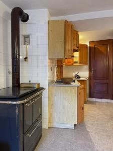 a kitchen with wooden cabinets and a black stove at Il Nido di Letizia in Châtillon