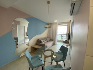 ein Wohnzimmer mit einem Glastisch und Stühlen in der Unterkunft Smart Stay P.Verde Apto 1011-Mandi Hospitalidade(Vista Mar) in Maceió