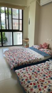 2 Betten in einem Zimmer mit einer Bettdecke mit Blumen in der Unterkunft Return to the Garden with Thoughts 隨思還園民宿 台東縣民宿第1926號 in Taitung