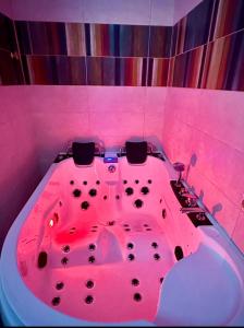 eine rosa Badewanne im Bad mit rosa Licht in der Unterkunft Suite prestige « Paradis » 5* au Moulin d’Albias in Albias