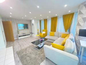 a living room with a white couch and yellow accents at Canary wharf the heart of London in London