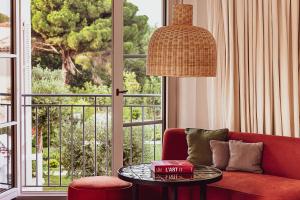 a living room with a red couch and a table at Hotel Lou Pinet in Saint-Tropez
