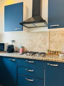 a kitchen with blue cabinets and a stove top at Appartement Marsa Ville in La Marsa