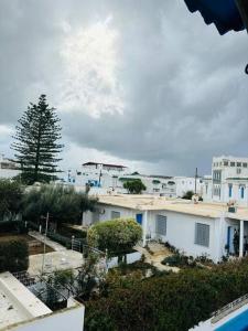 a group of white buildings with a tree in the background at Appartement Marsa Ville in La Marsa