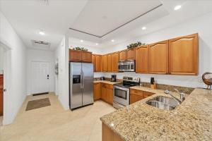 a kitchen with wooden cabinets and a stainless steel refrigerator at 3329 Purple Martin 112 in Punta Gorda