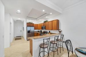 a kitchen with a counter and bar stools at 3329 Purple Martin 112 in Punta Gorda