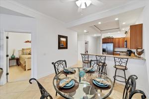 a kitchen and dining room with a glass table and chairs at 3329 Purple Martin 112 in Punta Gorda