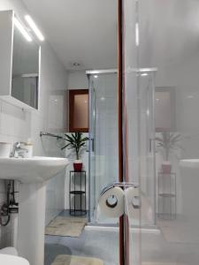 La salle de bains blanche est pourvue d'un lavabo et d'une douche. dans l'établissement South Street 46, à La Valette
