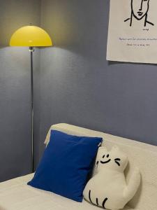 a pillow sitting on a bed next to a lamp at Blue Fever - Foreigner only in Seoul