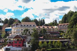 a group of buildings on a hill with trees at Hotel Leão da Montanha in Campos do Jordão