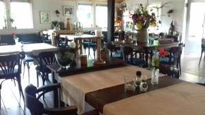 ein Restaurant mit Tischen und Stühlen mit Blumen darauf in der Unterkunft Camping de Zwammenberg in De Moer