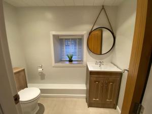 une salle de bain avec toilettes, lavabo et miroir dans l'établissement Stone Cottage, à Morpeth 5 autres photos