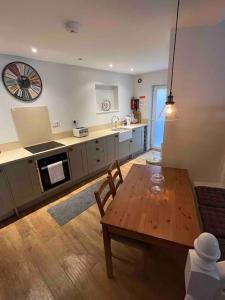 a living room with a table and a kitchen at Stone Cottage in Morpeth