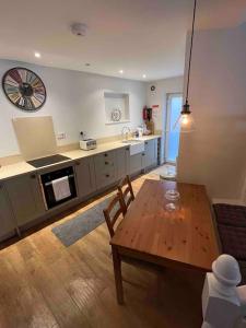 un salon avec une table et une cuisine dans l'établissement Stone Cottage, à Morpeth