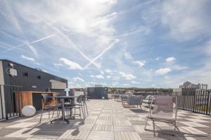 a patio with chairs and a table on a roof at FINESTATE Coliving Mairie d'Issy in Issy-les-Moulineaux