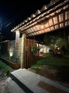 a wooden pergola in a yard at night at Family Guest House in Ilha de Boipeba