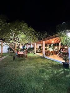 a backyard at night with people sitting at tables at Family Guest House in Ilha de Boipeba