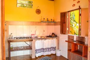 a kitchen with a sink and a stove top oven at Family Guest House in Ilha de Boipeba