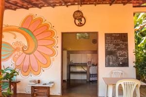 a kitchen with a wall with a flower painted on it at Family Guest House in Ilha de Boipeba